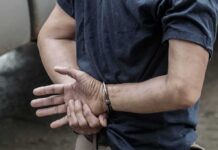 Virginia Man Charged After Allegedly Taping Wife person in handcuffs with hands behind back
