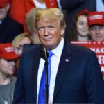 Chaos Erupts: Protesters Flood Trump Rally Donald Trump at a rally speaking at a microphone