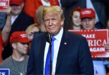 Donald Trump at a rally speaking at a microphone