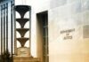 White House Access Meltdown Triggers Probe Department of Justice building exterior with sign and metal sculpture