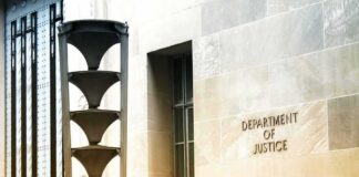 Department of Justice building exterior with sign and metal sculpture
