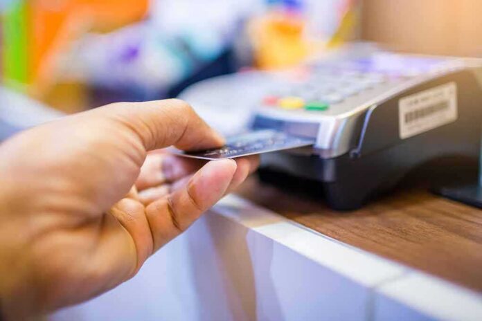 Hand inserting credit card into point-of-sale terminal