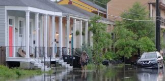 Person walking through flooded residential street