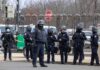British Base Scare – Tehran Named Group of police officers in riot gear standing on a street; Brian Folkerts present