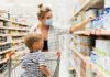 Woman wearing mask shops with child in grocery aisle
