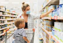 Woman wearing mask shops with child in grocery aisle