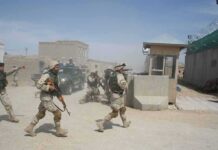 Ceasefire Mirage: Ethiopia Teeters Again Soldiers in desert uniforms run past a checkpoint amid dust