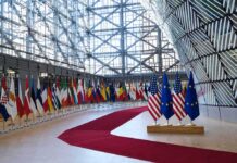Canada Ditches US? EU Makes Bold Move Row of national flags in a modern glass atrium with red carpet and EU and US flags upfront