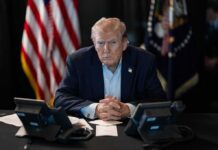 France Erupts – Trump Demands Border Clampdown Donald Trump seated at a table between two desk phones