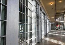 Prison cell block with metal bars and corridor